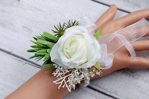 Dettaglio del fiore da polso rosa bianca con foglie verdi e bracciale di perle