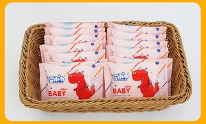Pink portable baby wipes with red dinosaur pattern in a brown woven storage basket