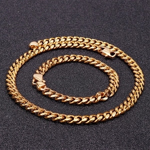 Ensemble collier et bracelet à mailles gourmette dorées en acier sur fond noir texturé