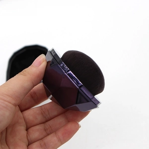 Detail of purple diamond-cut metal handle and dense black fiber bristles on foundation brush