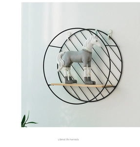 Detalle de estante de pared redondo de hierro negro con tabla de madera y diseño circular