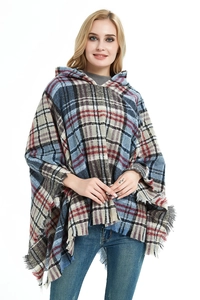 Dettaglio macro del poncho con cappuccio a quadri con motivo tartan blu e rosso e frange