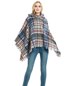 Dettaglio dell'orlo con frange su un poncho con cappuccio a quadri blu da donna
