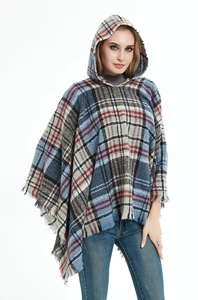 Dettaglio di un poncho con cappuccio a quadri multicolore con frange e trama in maglia