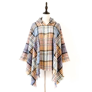 Dettaglio del poncho a quadri colorati con cappuccio e orlo a frange su sfondo bianco