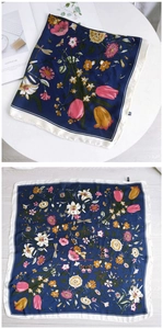 Detail of navy floral silk scarf with elegant botanical patterns and a satin texture finish