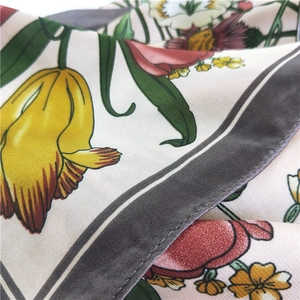 Detailed view of floral silk scarf with yellow tulips and soft satin texture fabric