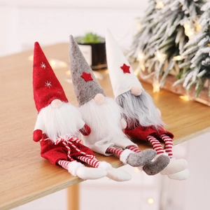 Three Christmas gnomes with red, white and grey hats sitting on a wooden table edge