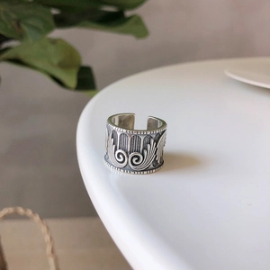 Close-up of vintage 925 silver wing ring with intricate engraved floral pattern
