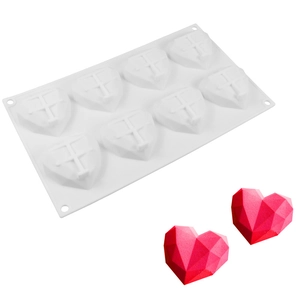 Detail of 8-cavity white silicone mold with geometric heart shapes and red mousse cakes