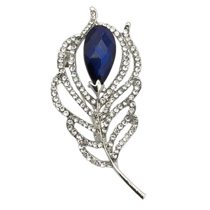 Macro detail of leaf brooch with blue pear-cut crystal and sparkling white rhinestones
