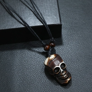 Tribal resin skull pendant necklace with black woven cord and wooden beads on leather