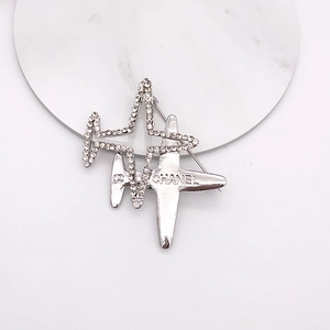 Macro shot of airplane brooch with sparkling rhinestones and silver finish details