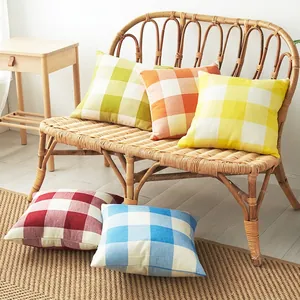 Linen plaid cushion covers in various colors displayed on a woven bench for home decor