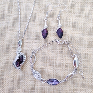 Detailed set of silver crystal jewelry including purple teardrop necklace and earrings