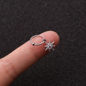 Dettaglio di un orecchino in acciaio argentato con un ciondolo a stella in zircone lucido