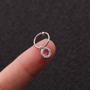 Macro di orecchino a cerchio in acciaio argento con pendente in zircone sul polpastrello