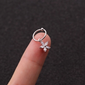 Vista dettagliata di un anello a fiore in argento con zircone bianco sul dito