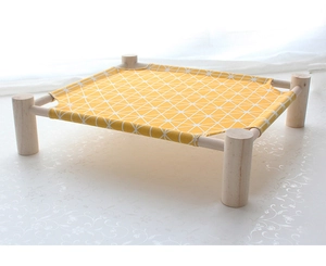 Detail of elevated wooden pet hammock with yellow geometric canvas for moisture-free rest