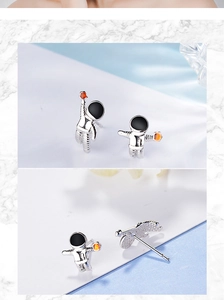 Detailed view of astronaut stud earrings with orange star and black enamel visor details