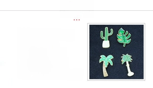 Détail de quatre épingles végétales en émail incluant cactus et feuilles de palmier