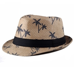 Detail of woven straw hat with black decorative ribbon and tropical palm tree pattern