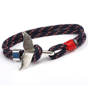 Handmade nautical paracord bracelet with silver whale tail charm on white background
