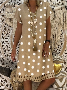 Detailed view of khaki V-neck polka dot dress featuring geometric cutout embroidery hem