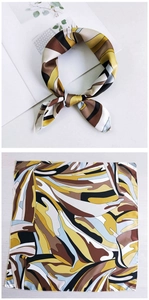 Detail of silk-feel square scarf with yellow and brown abstract wave patterns