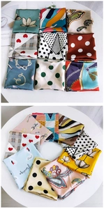 Flat lay of diverse patterned silk scarves with floral, polka dot and flamingo designs