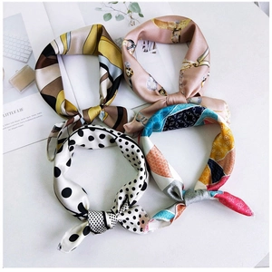 Detail view of four assorted silk neck scarves with vibrant patterns on white background