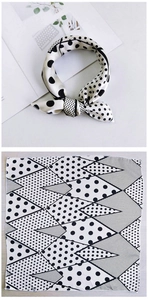 Detail of silk-like scarf with black and white polka dots and geometric patterns