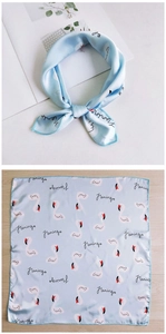 Detail of light blue silk scarf with flamingo print and artistic calligraphy text