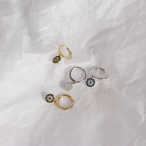 Detail view of S925 sterling silver evil eye hoop earrings in gold and silver finish