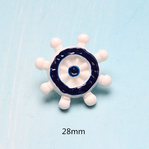 Detail shot of a 28mm white and blue resin ship wheel for DIY phone cases or resin crafts