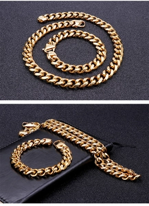 Close-up of golden Cuban link chain set with lobster clasp on a dark textured background