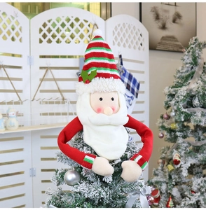 Detail of plush Santa Claus tree topper decoration on a festive Christmas tree