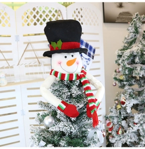 Detail of felt snowman Christmas tree topper with black hat and striped scarf decoration