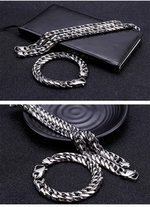 Close-up of polished silver stainless steel Cuban link necklace and bracelet set