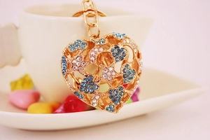 Macro shot of heart-shaped gold keychain with blue rhinestones and star moon cutouts