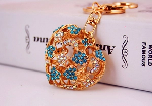 Detail of heart-shaped hollow keychain with blue rhinestones and moon star patterns