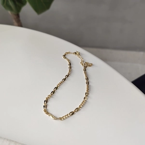 Minimalist 925 sterling silver anklet in golden finish displayed on a white podium