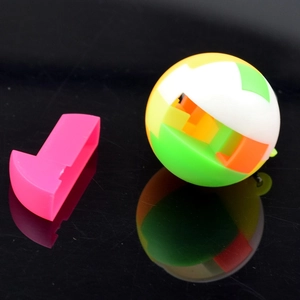 Detail of colorful plastic puzzle ball showing individual pink part on reflective surface