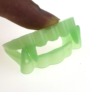 Macro view of light green translucent plastic vampire fangs for Halloween props