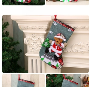 Detail view of a green Christmas stocking with a 3D bear and tree decor hanging on a fireplace