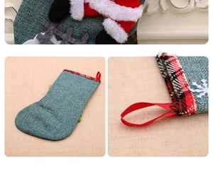 Close-up of green burlap Christmas stocking with Santa 3D motif and plaid cuff details