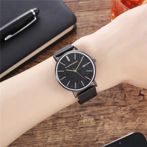 Men's business quartz watch with black starry sky dial and mesh strap on a wooden desk