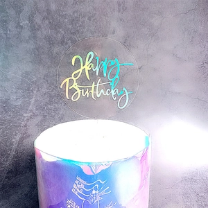 Holographic acrylic Happy Birthday cake topper with laser effect on a decorated cake