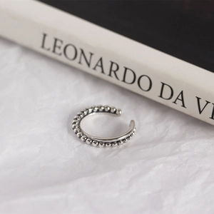 Detailed macro view of minimalist S925 sterling silver beaded chain ear cuff design