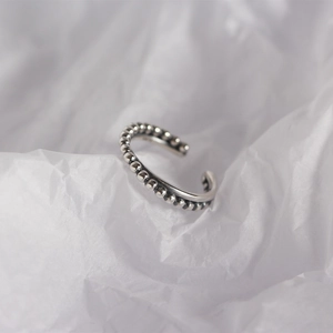 Macro detail of S925 sterling silver beaded ring with adjustable open band on white background